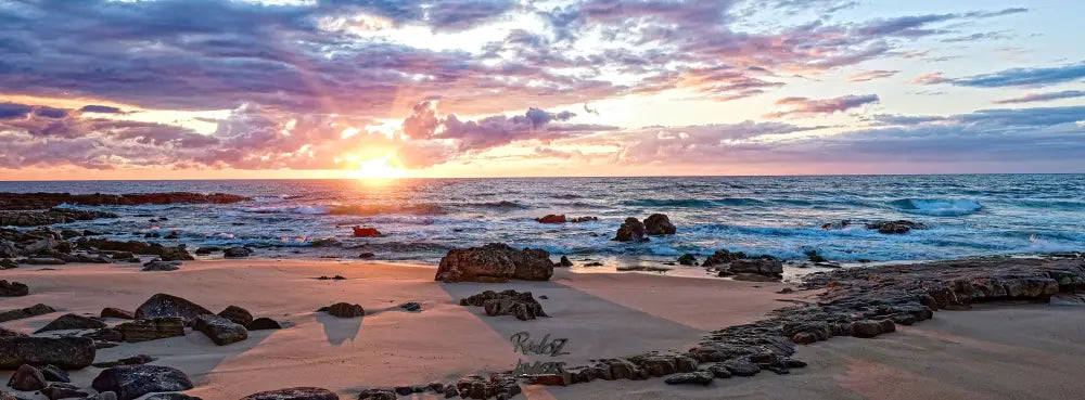 Sunrise over rocks on cloudy day Australian coastal panoramic seascape