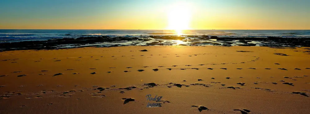 Footprints in sand at sunrise Australian beach panoramic landscape