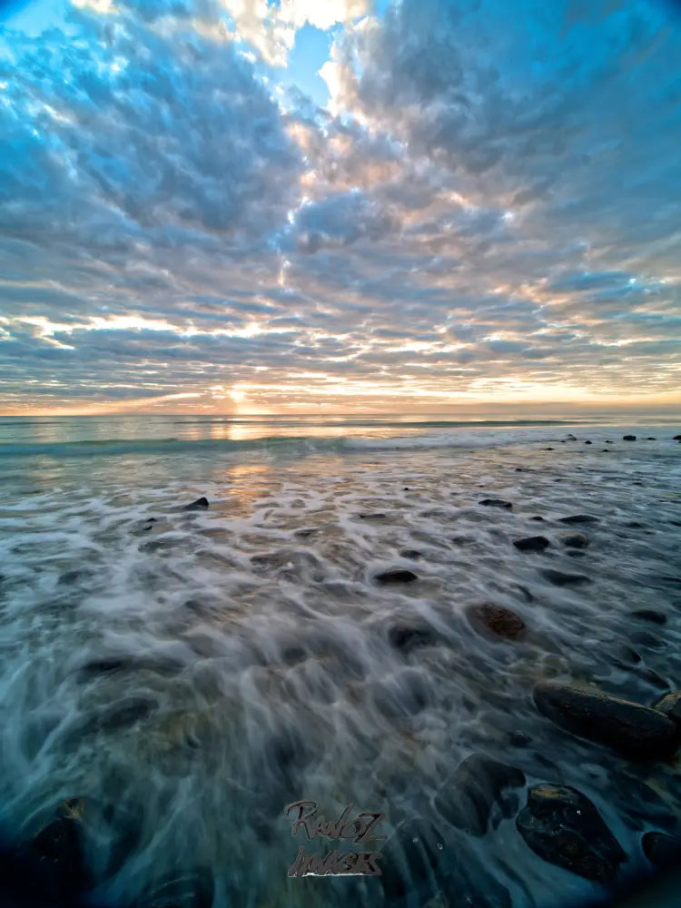 Cloudy dawn sky mirrored in calm water at Coral Cove Queensland
